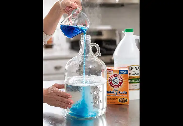 Pouring dish soap into gallon jug with warm water