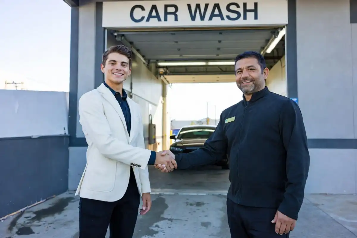 A job applicant shaking hands with a car wash manager at a hiring interview