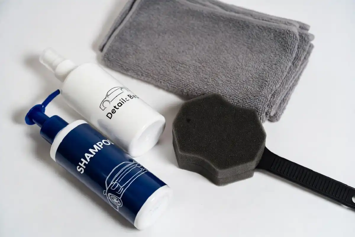 Closeup of car wash kit products including shampoo, wax, and microfiber cloth on a table