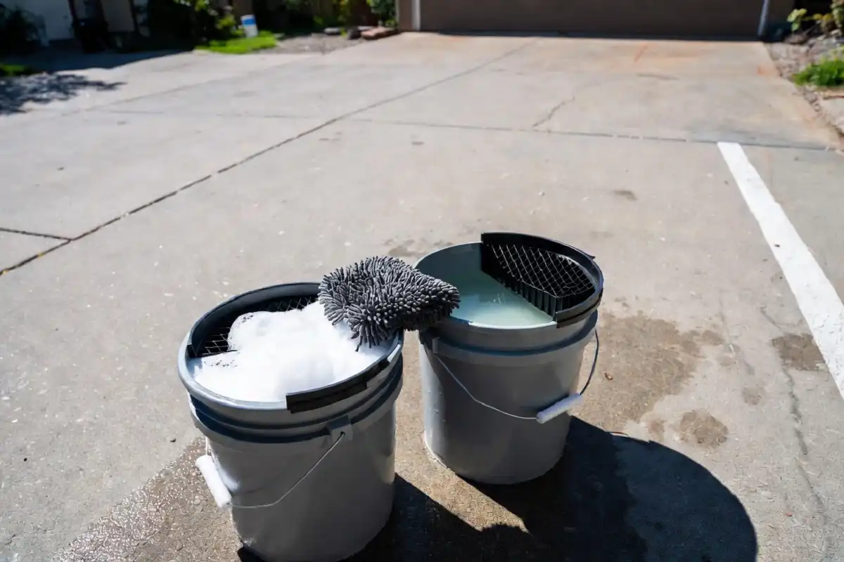 Two-bucket car wash method setup with grit guards and microfiber mitt