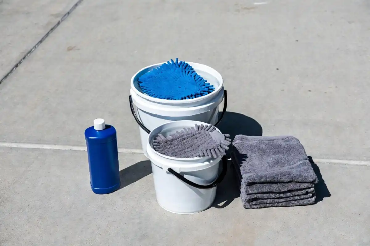 DIY car wash supplies arranged on a driveway