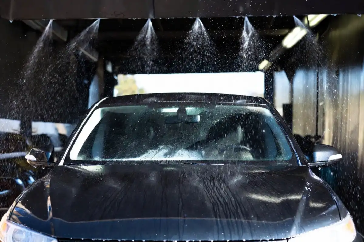 Clean shiny car exiting a drive through car wash with air dryers blowing