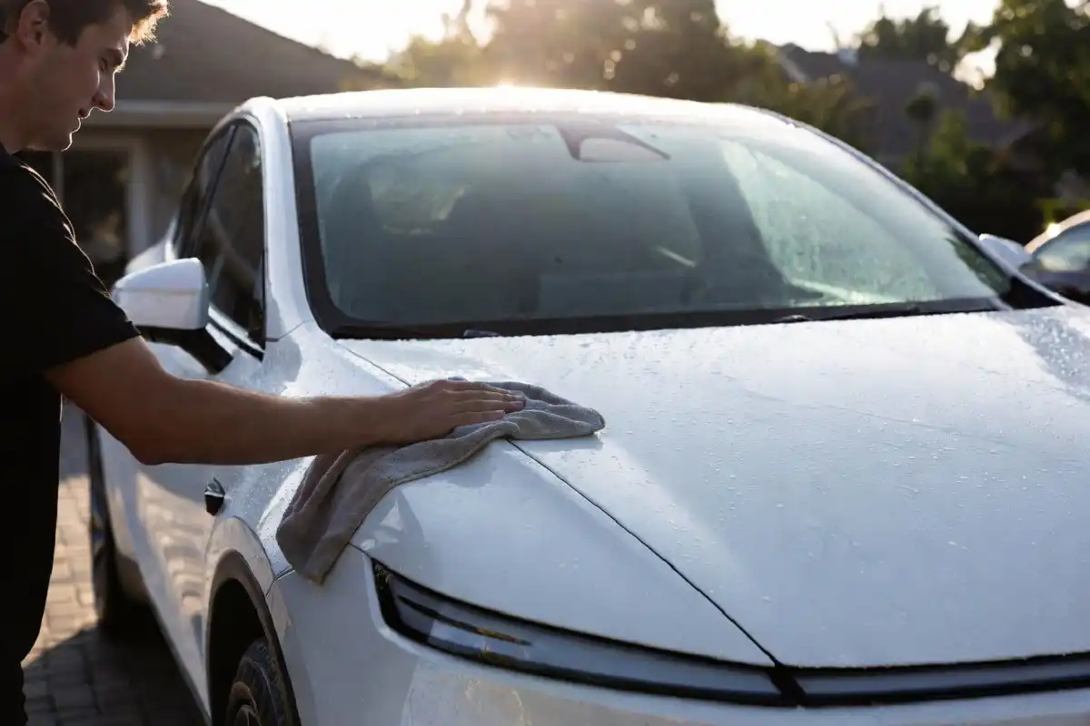 Drying a car with a microfiber towel for a streak-free bliss finish