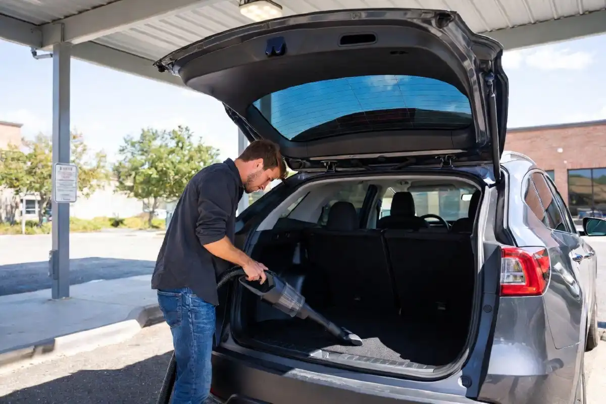 Customer vacuuming car interior at Whitewater Express Car Wash vacuum