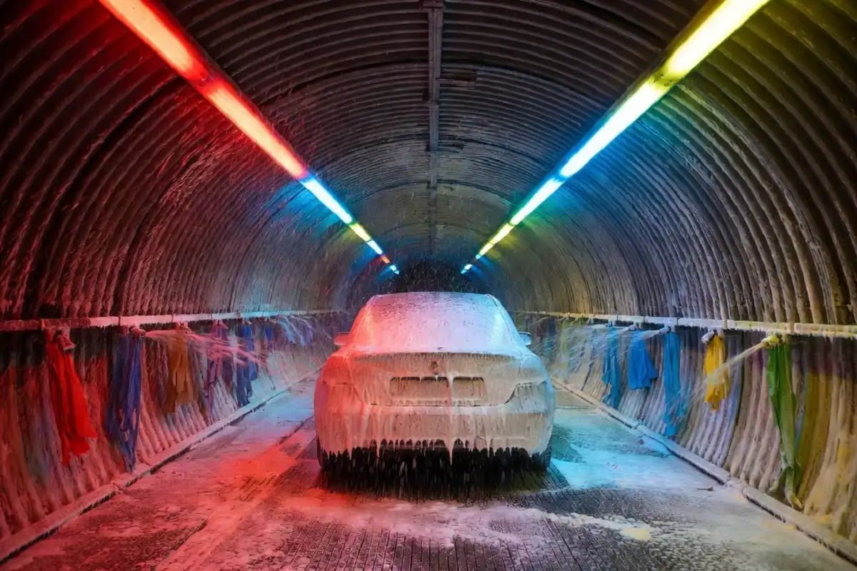 Interior of an express car wash tunnel showing foam applicators and water jets