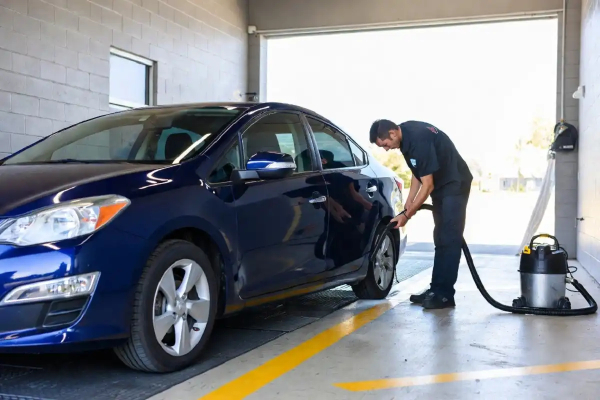 Staff vacuuming car interior during a full-service wash