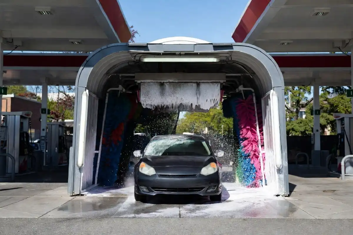 A car entering a gas station car wash tunnel at a busy fuel station Placement: Below the introduction