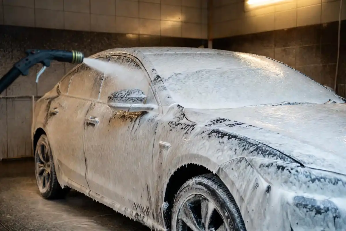 Car covered in thick white foam at a self-service car wash