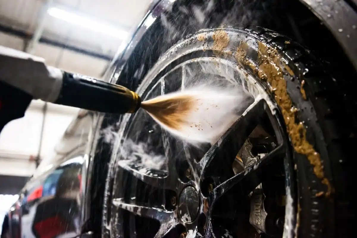 Wheel and rim being cleaned at a self wash car wash with high pressure wand