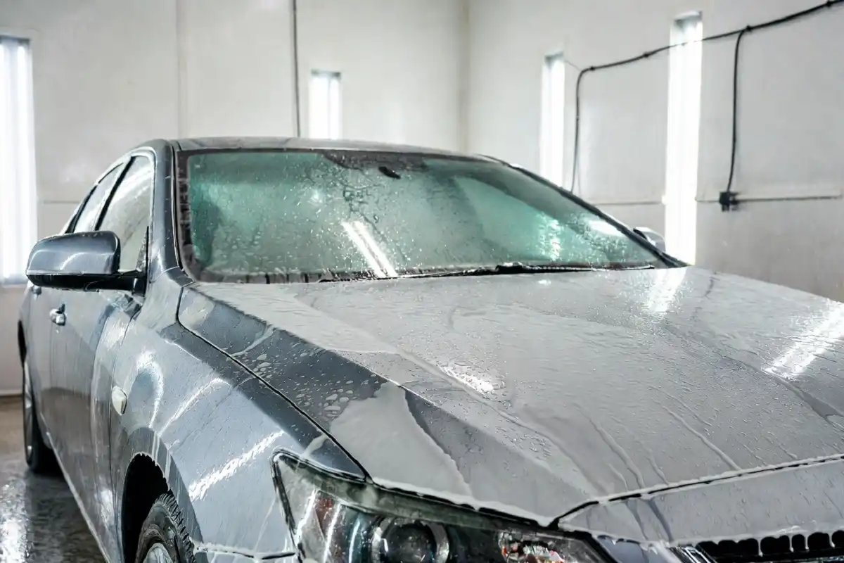 A clean silver car after a sparkling image car wash with water beading on the hood