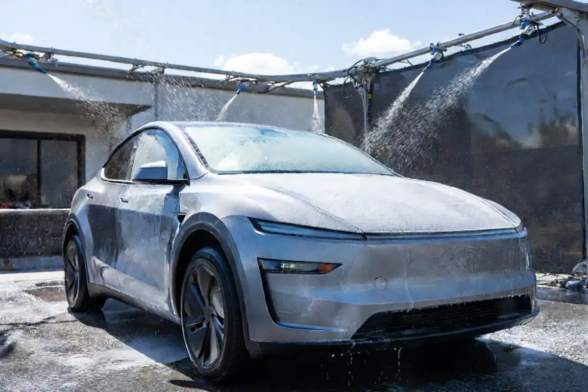 Tesla vehicle being cleaned at a touchless car wash station
