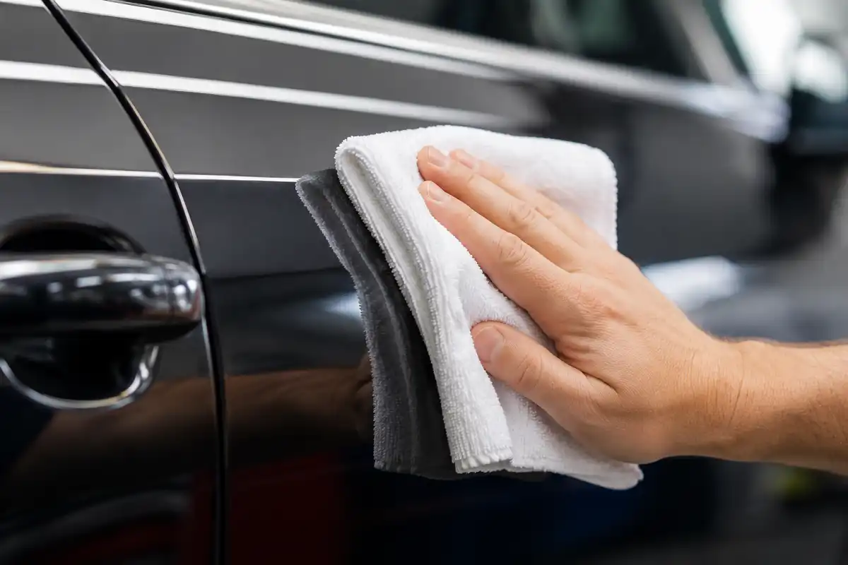 Microfiber cloth being used to buff a car panel during a waterless wash