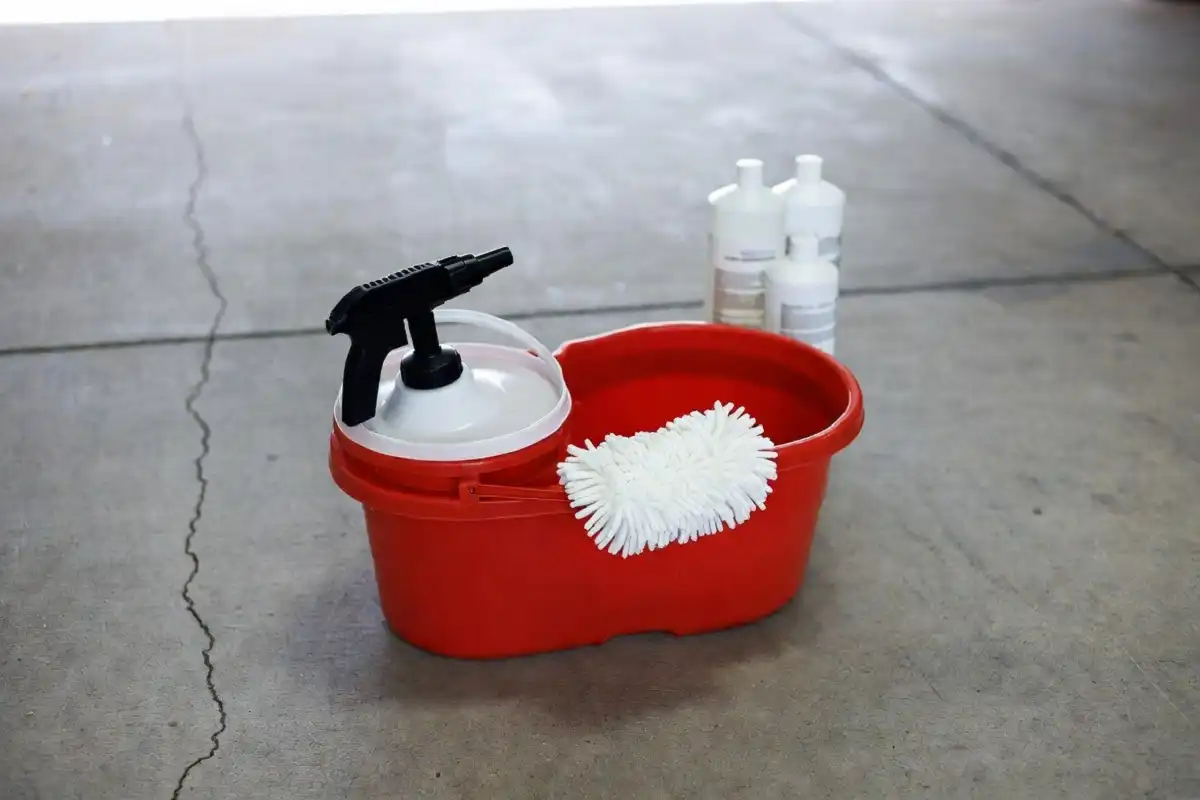Car wash bucket, microfiber mitt, and soap bottles set up for a white water car wash